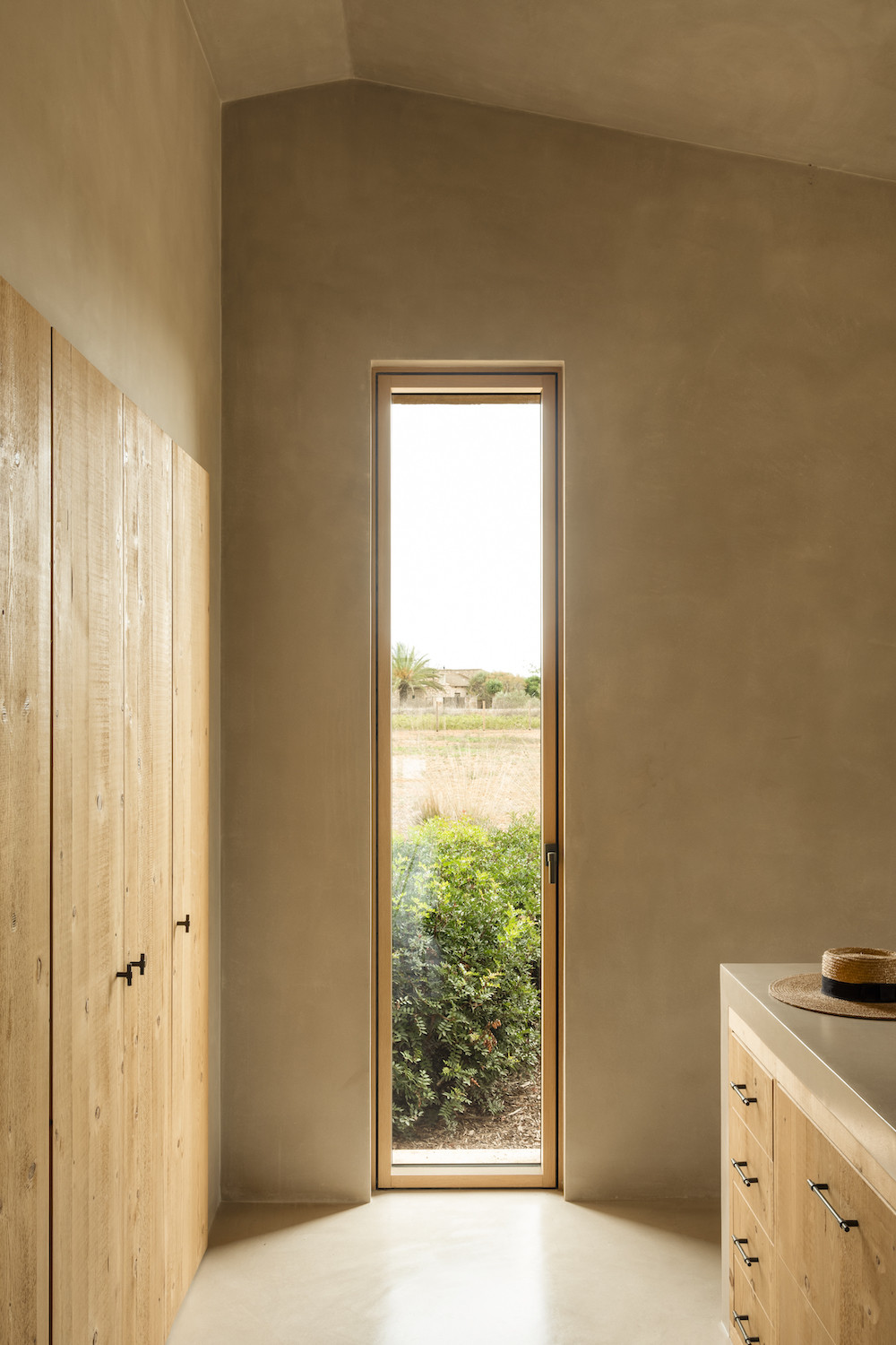 Pasillo con ventana vertical y carpintería de madera, Ca Na Lola, Mallorca