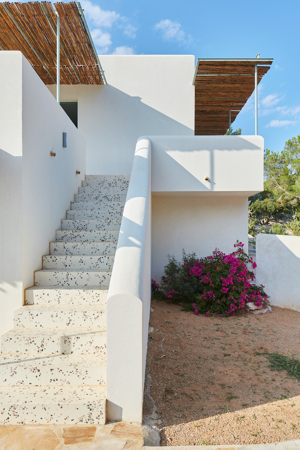 Escalera exterior de piedra junto a buganvilla, reforma Na Xamena, Ibiza