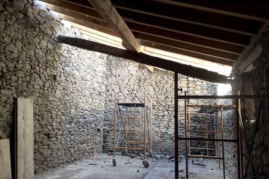 Reforma de una antigua borda del proyecto Benasque de KLARQ con paredes y tejados aún en construcción dejando entrar mucha luz natural.