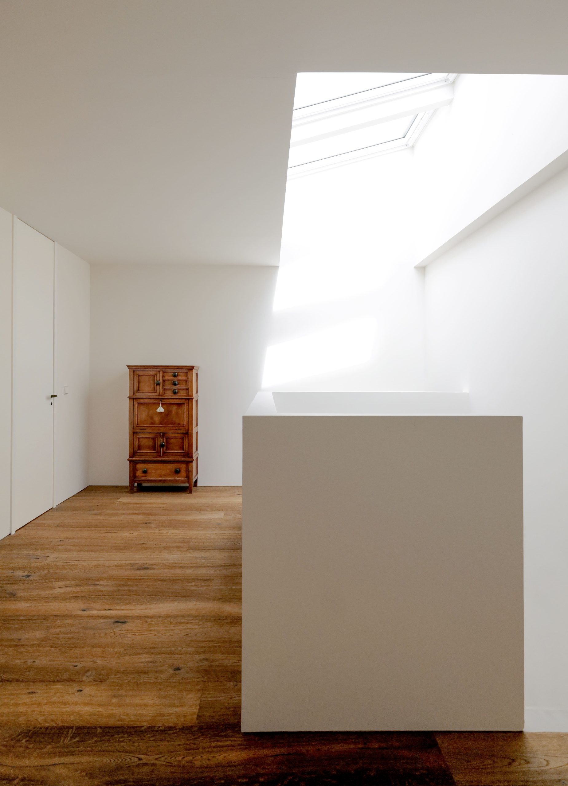 Interiorismo del proyecto de Tres Cantos del estudio de arquitectura KLARQ donde la decoración de madera destaca en los colores blancos de las paredes.