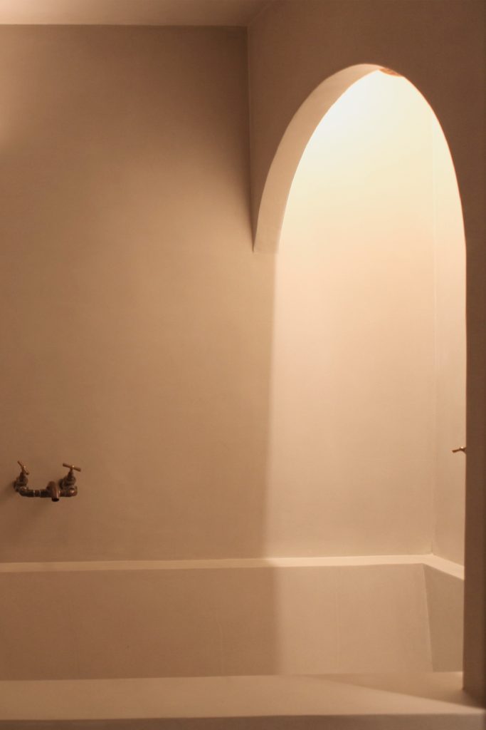 Interiorismo del baño del proyecto BENASQUE de KLARQ con una decoración y estética minimalista y de colores cálidos.